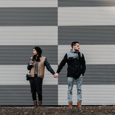 two people holding hands and looking away from each other