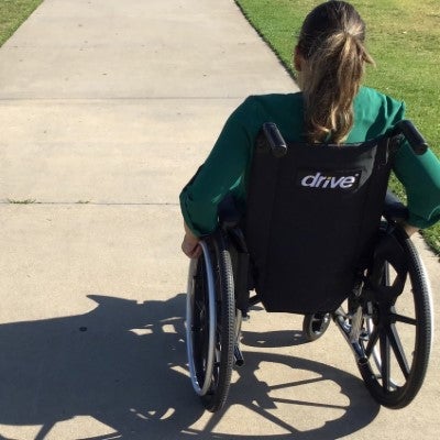 woman in wheelchair on sidewalk