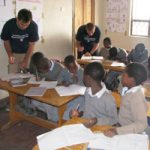 URI students working with children in a classroom in Tanzania