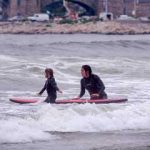 URI student teaching a child to surf