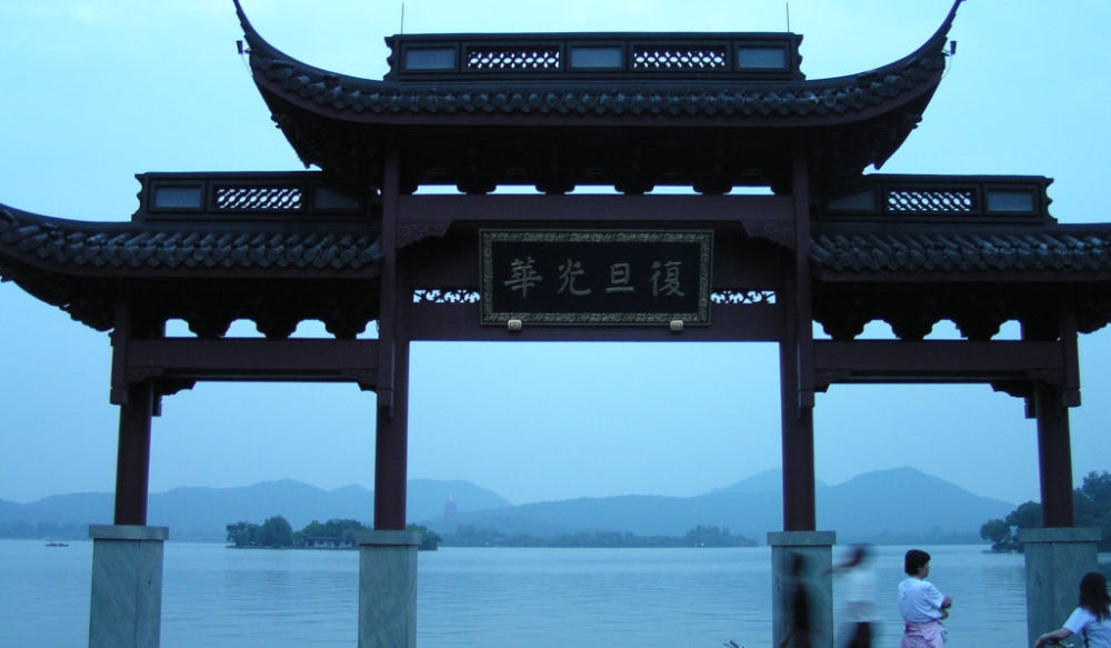 A covered archway beside a lake in China