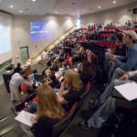 Students fill a room as they compete in the Calcbowl, holding notes and using buzzers.