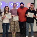 A group of first-place Cal Bowl contestants stand together, smiling and holding their awards.