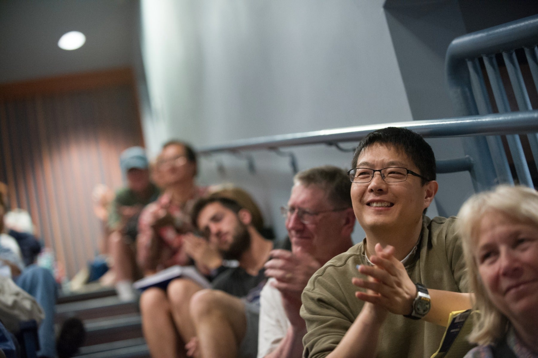 Man in a lecture hall clapping