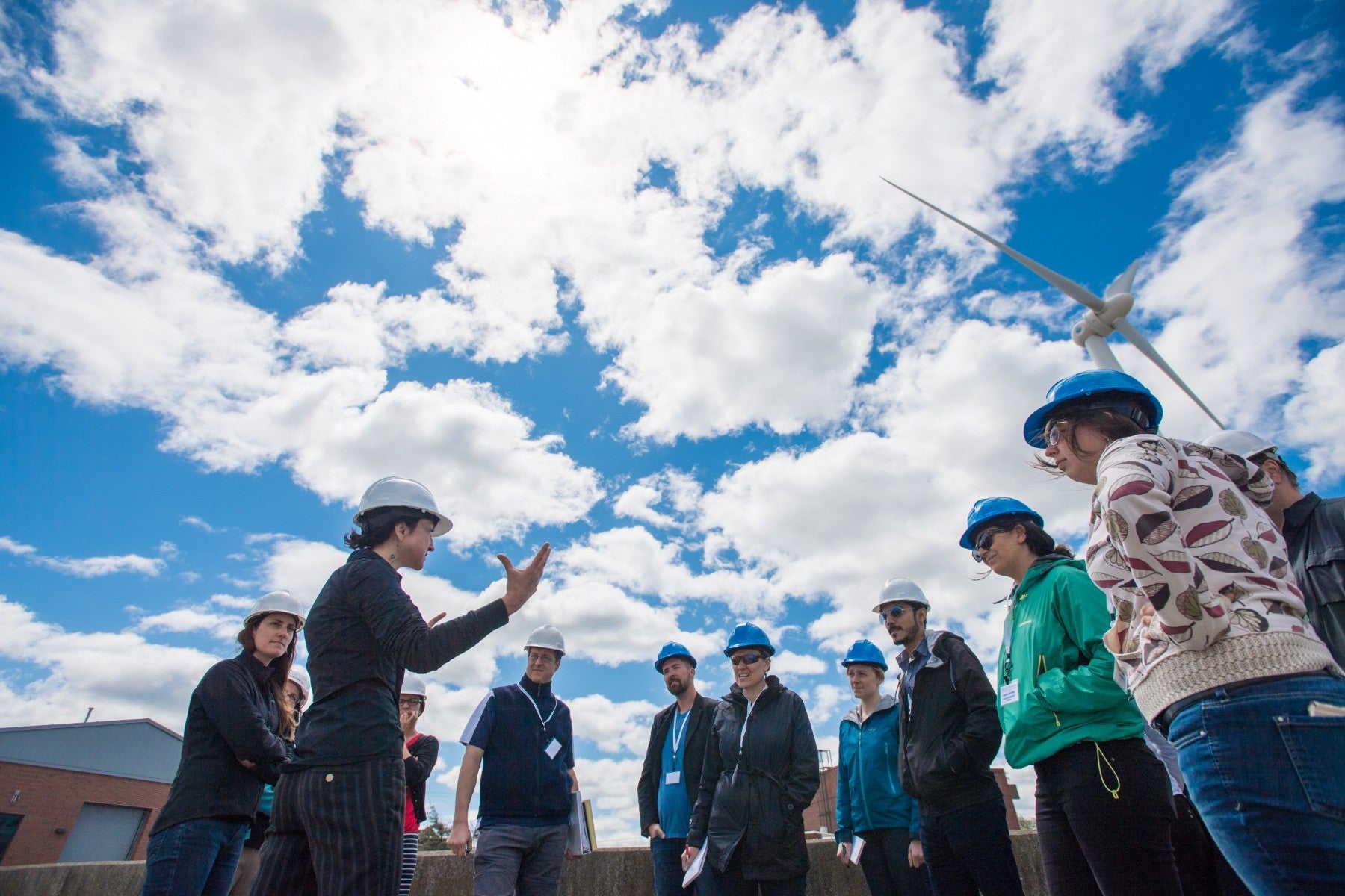 Group of people wearing hard hats underneath sky