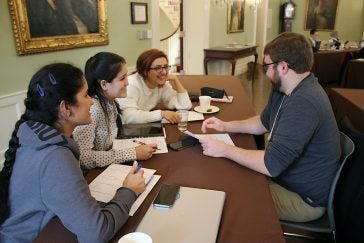 Photo of a group of students at a table talking