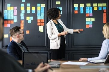 Photo of woman giving a presentation to a male and female colleague