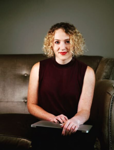 Photo of Emily Atkin sitting in chair holding a laptop