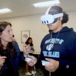 URI College of Nursing Simulation Education Coordinator Jessica Skatsis teaches nursing student Shakira Caffey how to use the equipment in the college's new virtual reality simulation lab.