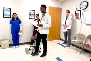 URI College Nursing, Pharmacy, and Health Sciences students interview a mock patient during RI Interprofessional Education Day at Brown University's Warren Alpert Medical School.
