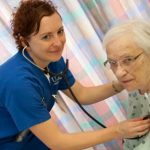 A nurse cares for an elderly woman.