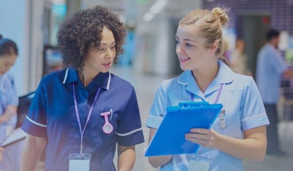 two nurses in a hospital setting engaged in conversation