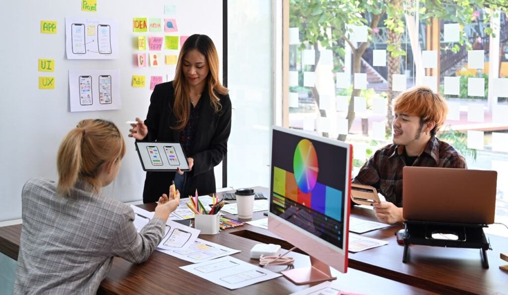 Female website designer showing user interface design on digital.