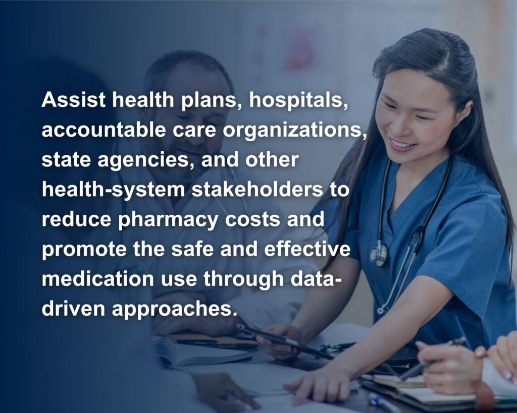 The image shows a group of healthcare professionals engaged in a discussion around a table in a well-lit room. The focus is on a female healthcare worker wearing blue scrubs and a stethoscope around her neck, who is smiling and pointing to a document on the table. Other team members, who are partially visible, are seated around the table holding pens and papers, indicating a collaborative meeting. The background is blurred to emphasize the individuals and their interaction. Overlaying the left side of the image is a bold white text paragraph. White text says "Assist health plans, hospitals, accountable care organizations, state agencies, and other health-system stakeholders to reduce pharmacy costs and promote the safe and effective medication use through data-driven approaches."