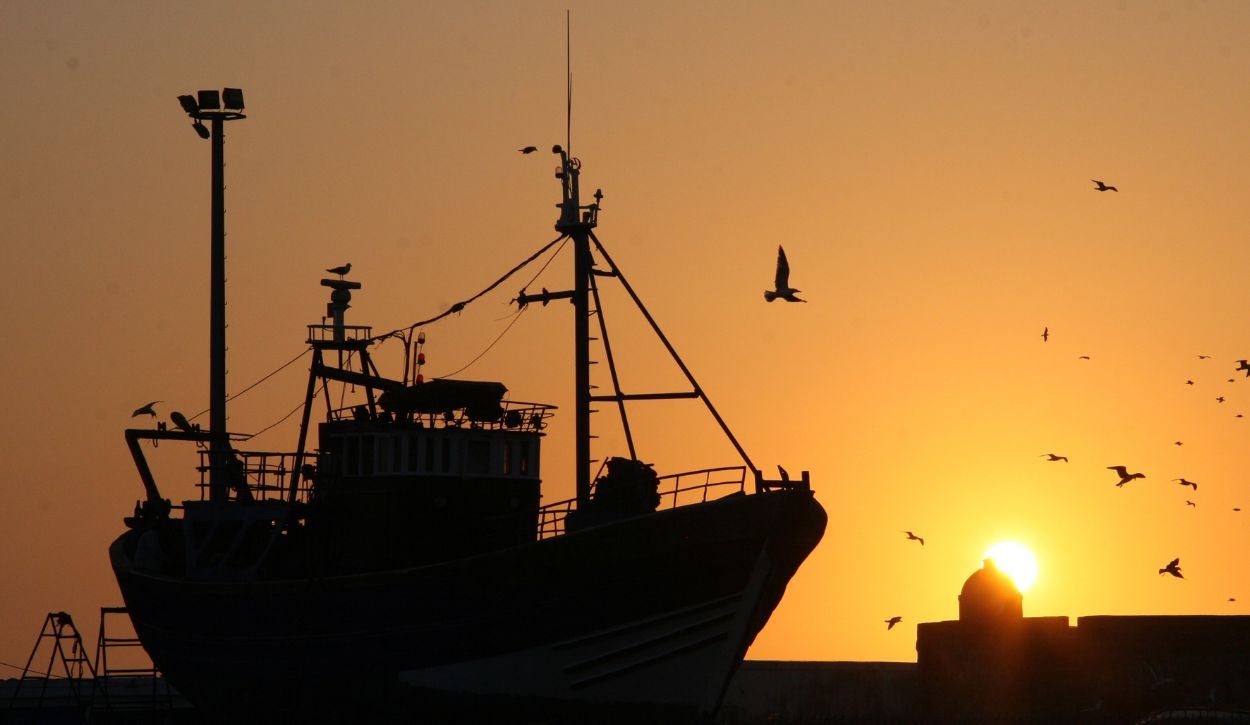 Silhouette of a fishing boat with the sunset in the background