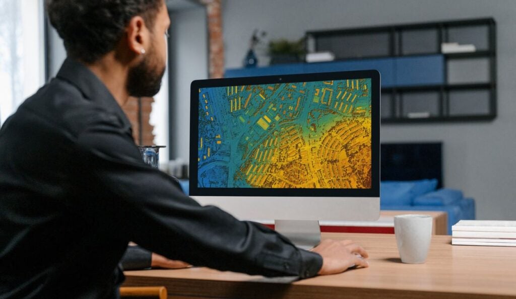 A GIS analyst reviews a map on his computer.