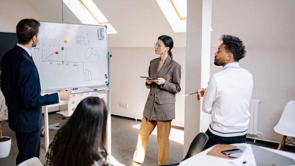 4 Professionals in a meeting looking at graphs and charts