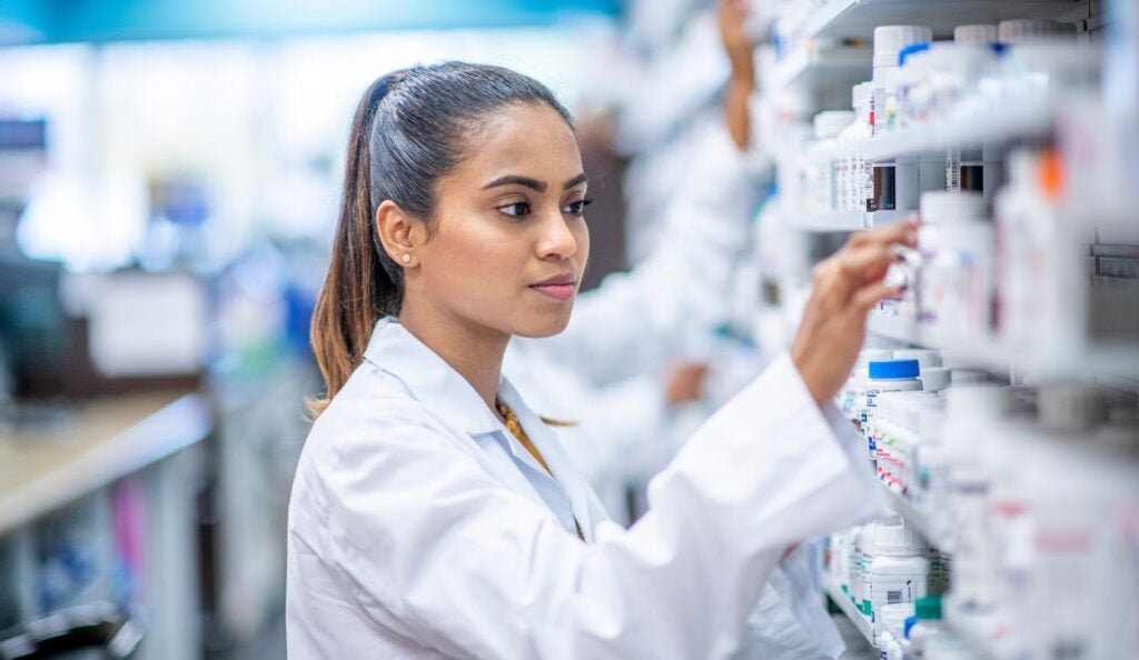Pharmacist looking through shelves in a pharmacy