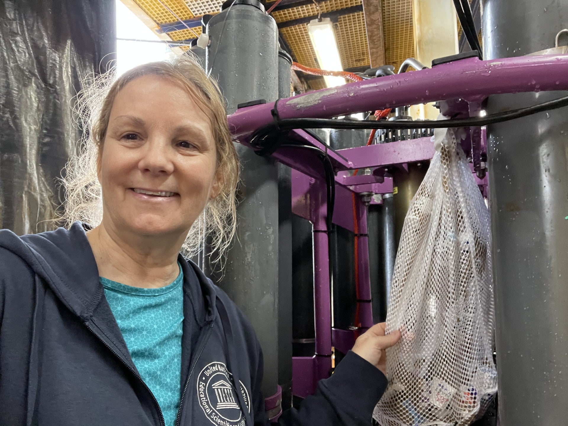 CTD Watchstander Teresa Kennedy (UT Tyler/URI) retrieves the second mesh bag of cups after the science team had taken their water samples from the Nisken bottles upon recovery.