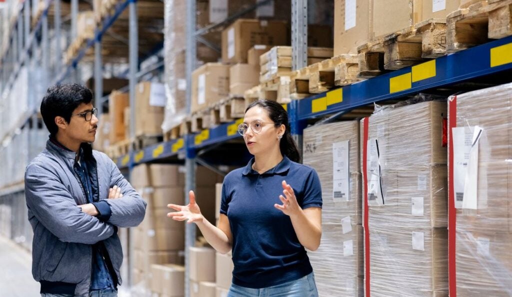 Professionals in a warehouse having a conversation.