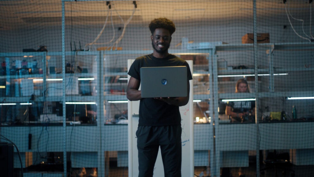 A male student works on a laptop in a computer lab