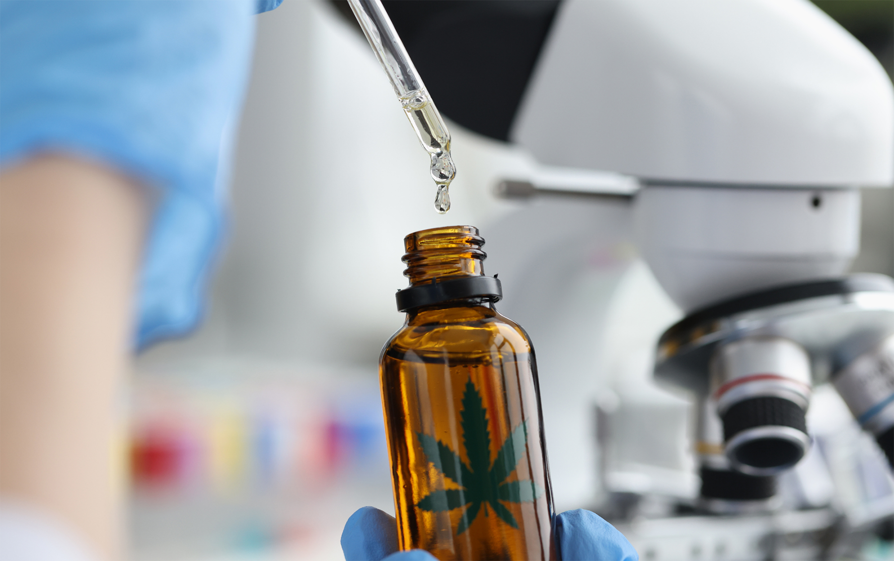 chemist in lab in front of microscope extracting cannabis oil