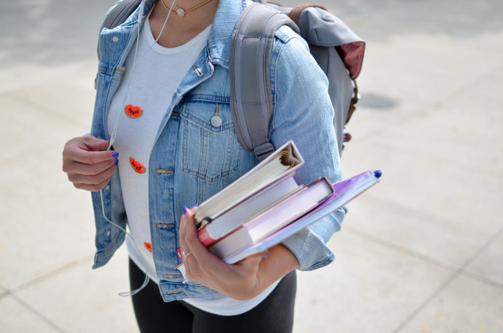 A student wearing a backpack and jean jacket