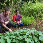 A Peace Corps volunteer in Nepal worked with a community member in a garden.