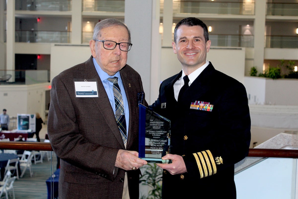 URI College of Pharmacy Professor Emeritus Norman Campbell presents Capt. Bill Lehault, pharmacist and officer of the United States Public Health Service Commissioned Corps, with the Campbell Award for Ethics and Excellence.