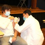 P3 Pharmacy student James Cocozza vaccinates first-year pharmaceutical sciences student Conor Looney.