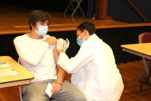P3 Pharmacy student James Cocozza vaccinates first-year pharmaceutical sciences student Conor Looney.