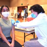 P3 student Michael Burkett vaccinates first-year PharmD student Sara Alani.