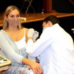 P3 student James Cocozza vaccinates sophomore Juliet Lenzo.