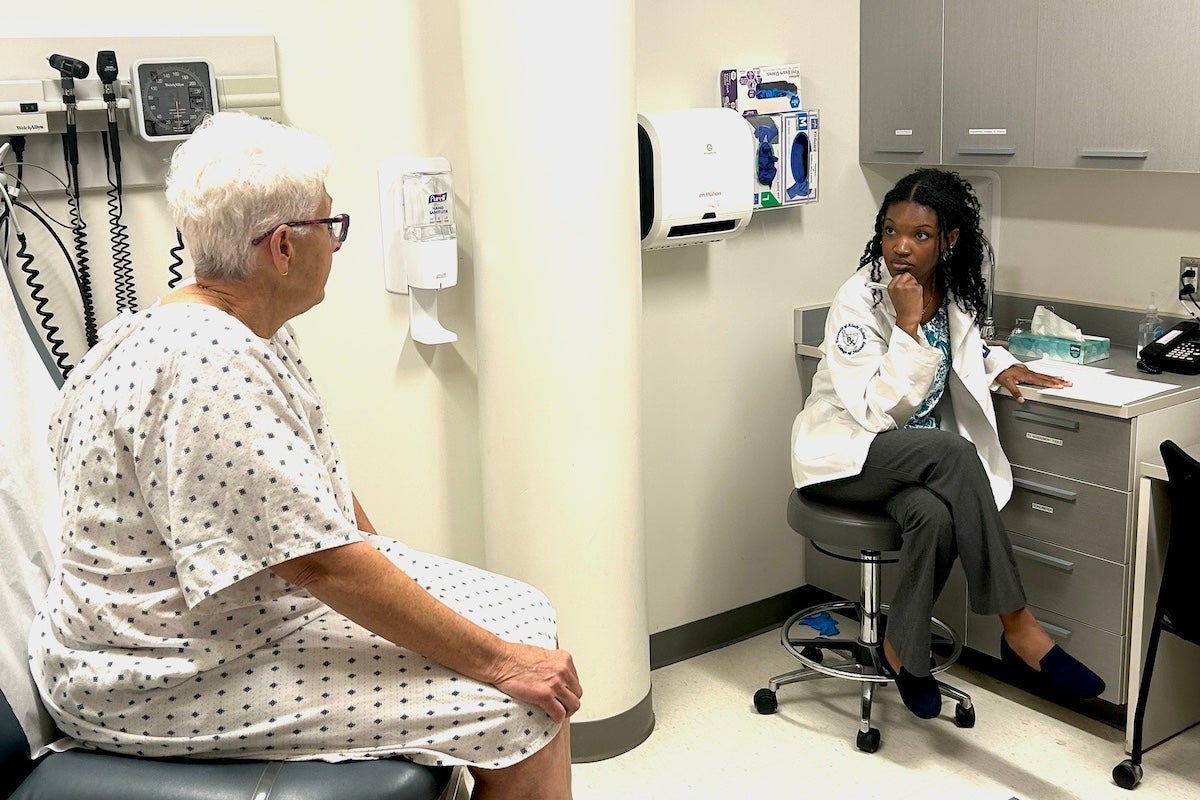 URI College of Pharmacy student Kai Reddie interviews a simulated patient portrayed by local actor Sue Hinckley about her medication use during the semiannual Interprofessional Education Day at Brown University's Warren Alpert Medical School Oct. 21.