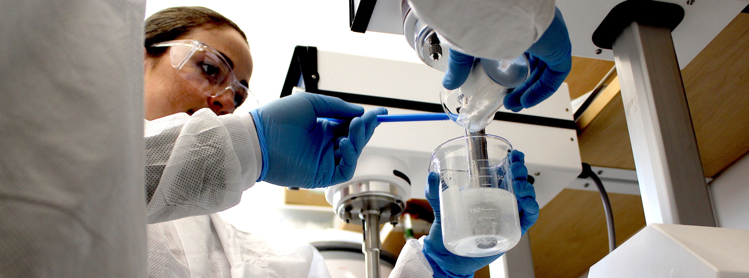 student mixing chemicals in a lab