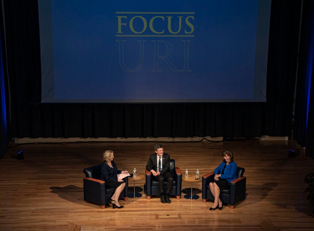 A high-up view of the stage, with Laurie White ’81, President Parlange, and Provost Barbara Wolfe seated.