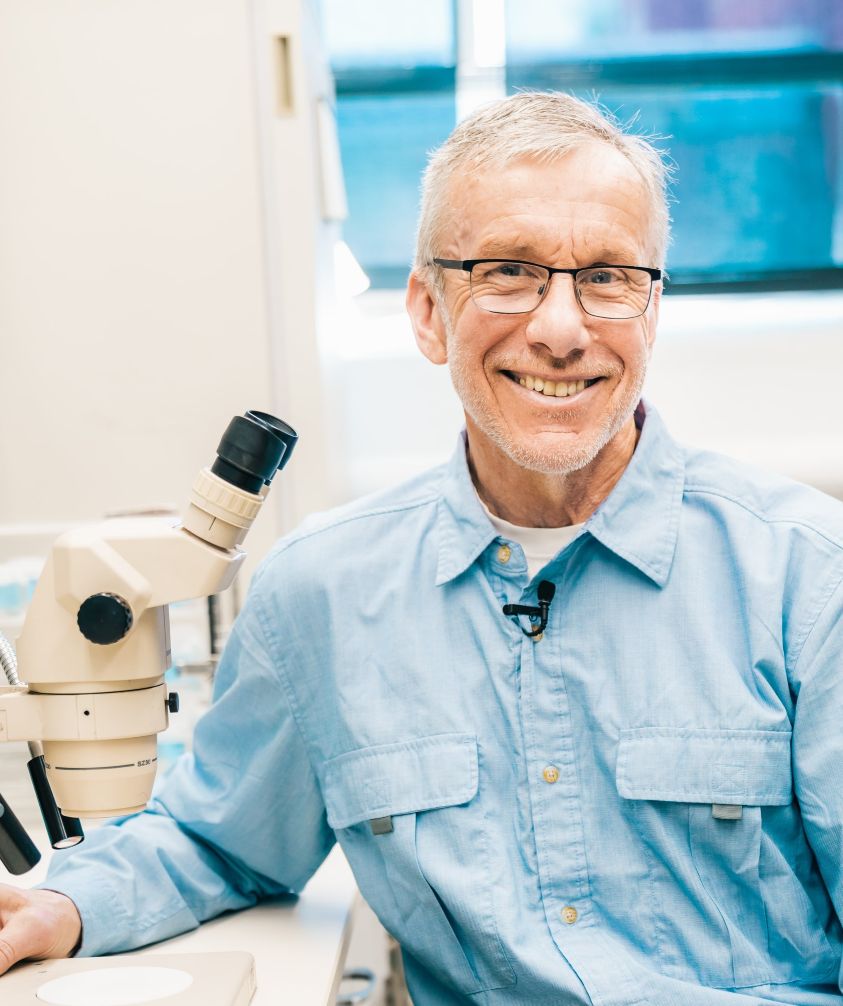 picture of tom next to a microscope.