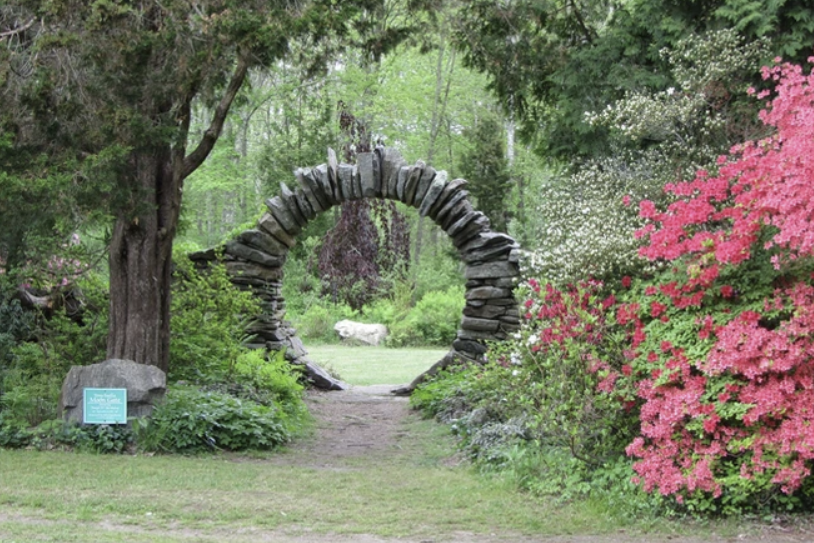 Stone circle arch with pink azaleas to the right