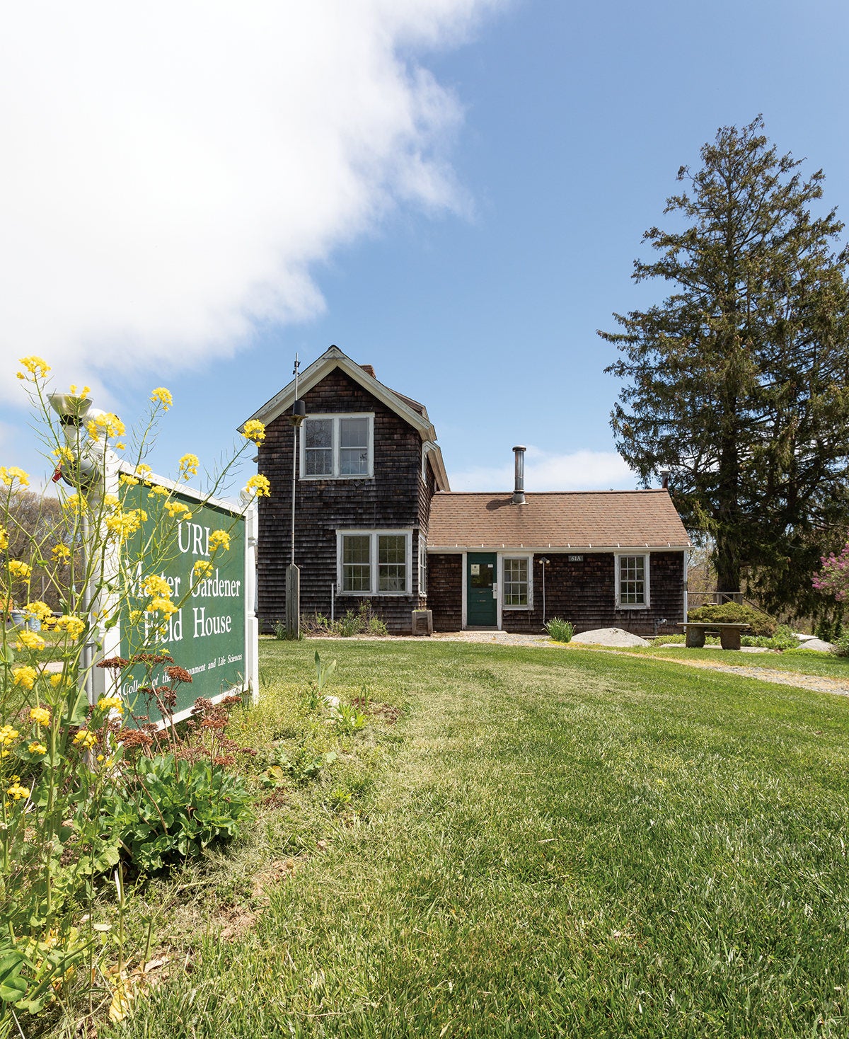 The URI Master Gardener Field House with flowers decorating the sign