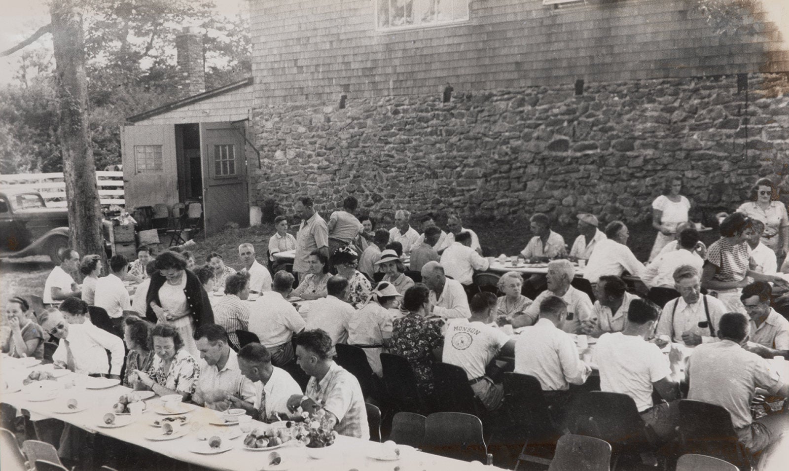 A black and white photo showing a banquet style outdoor gathering of local fruit growers from 1930