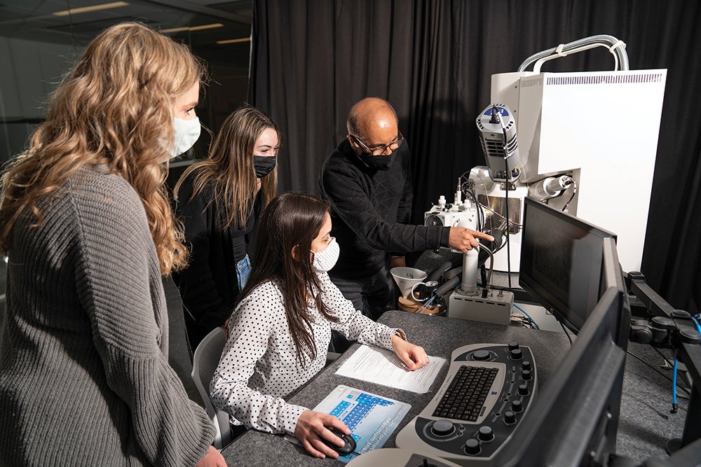 Students look at computer screen of images from CryoSEM with Dr. Arijit Bose