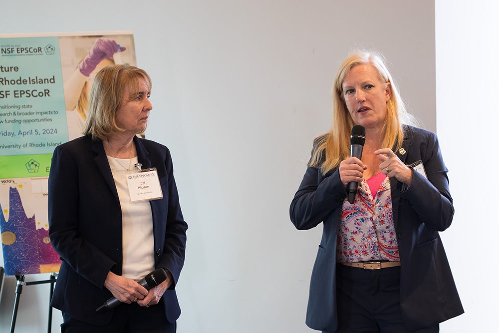 Jill Pipher and Bethany Jenkins, in formal wear, hold mics and speak