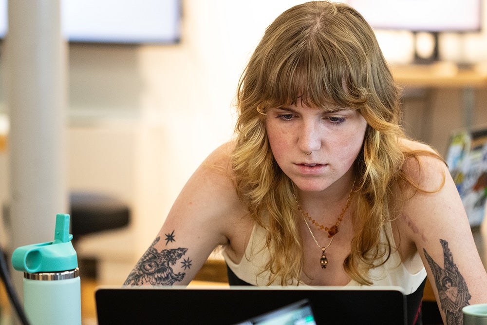 Ellen, a blonde haired student, stares intently at her laptop screen