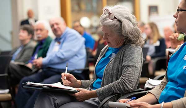 a woman writes during a meeting