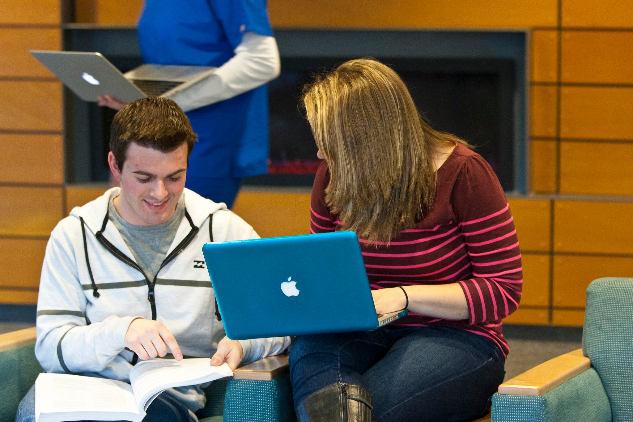 two students talk to each other while studying