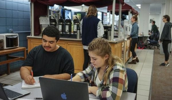 a pair of students study at a campus cafe