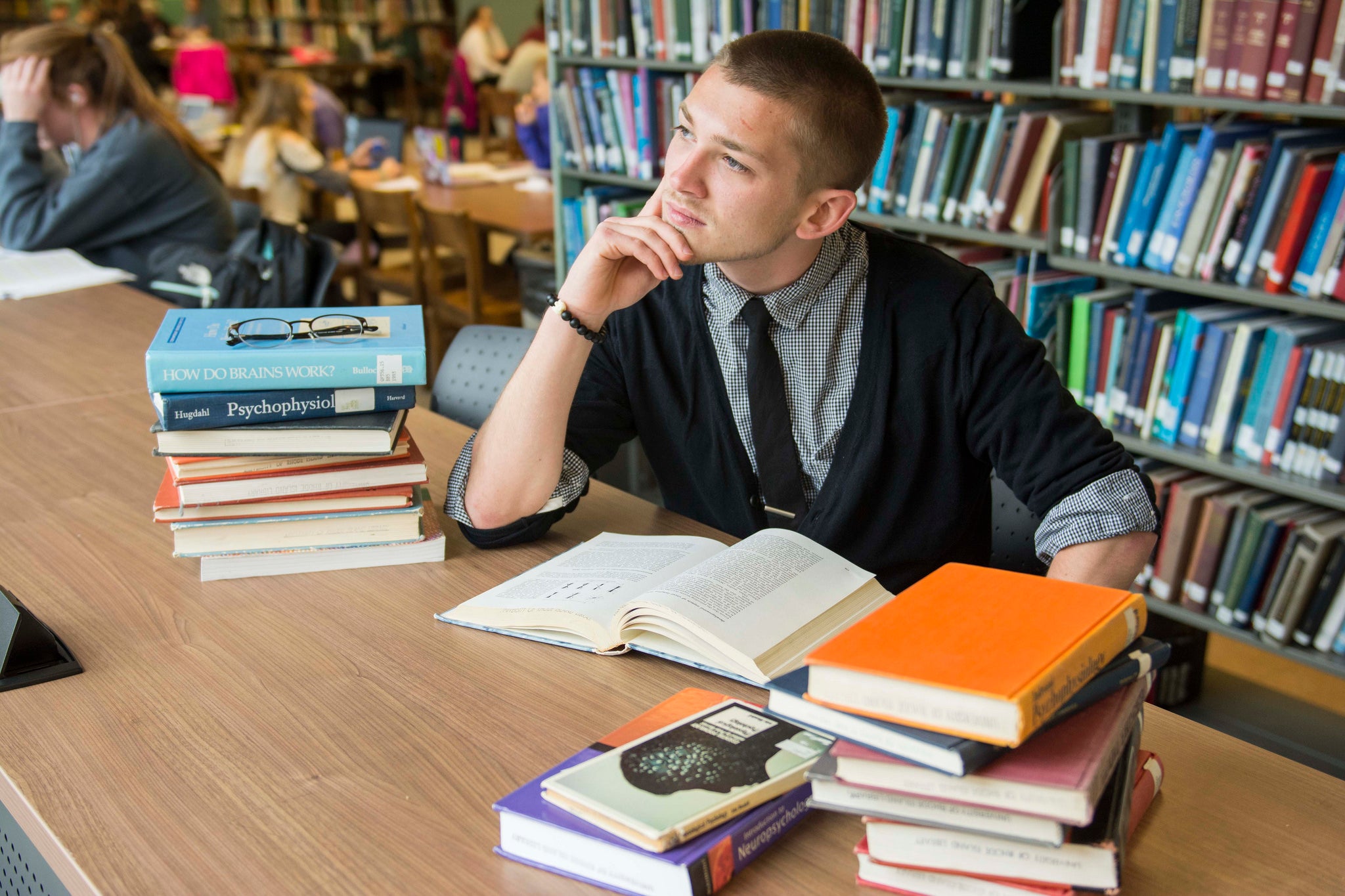 A young man sits and studies in a library