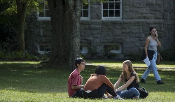 a student throws a frisbee while others watch