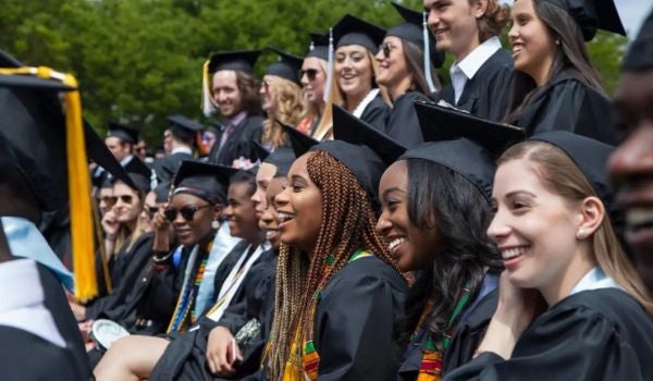 a large group of graduates sit at commencement