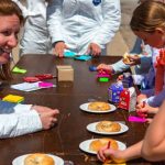 TickEncounter staff working with children to find nymphal ticks on poppyseed bagels